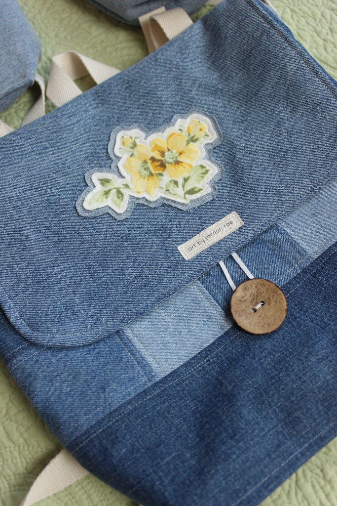 An up-close photo of a handmade denim bag with a floral patch on it
