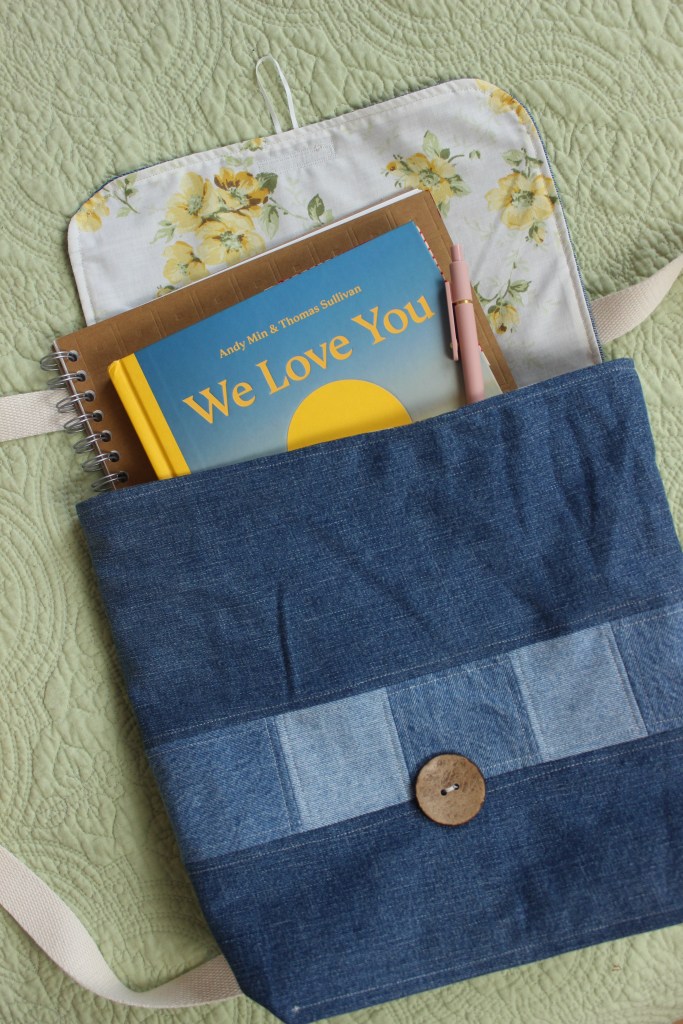A handmade denim bag with books in it
