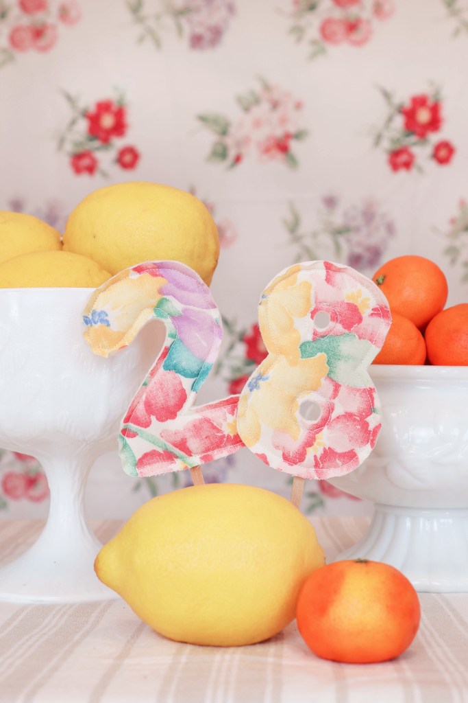 The number "28" stands in front of bowls of fruit.