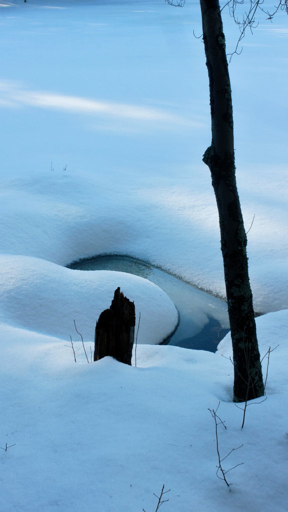 A pool of water surrounded by snow.