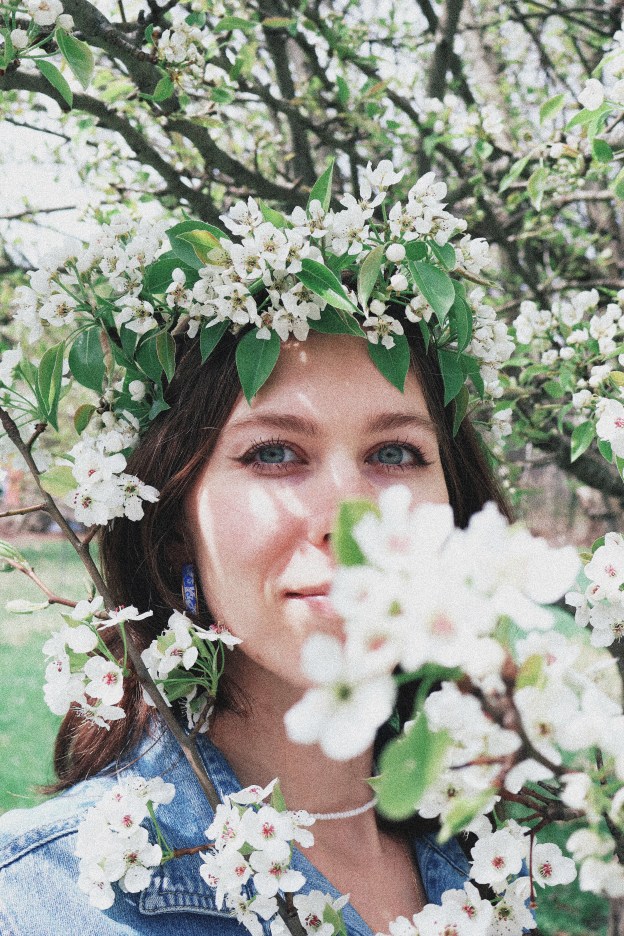 A girl standing surrounded by pear blossoms