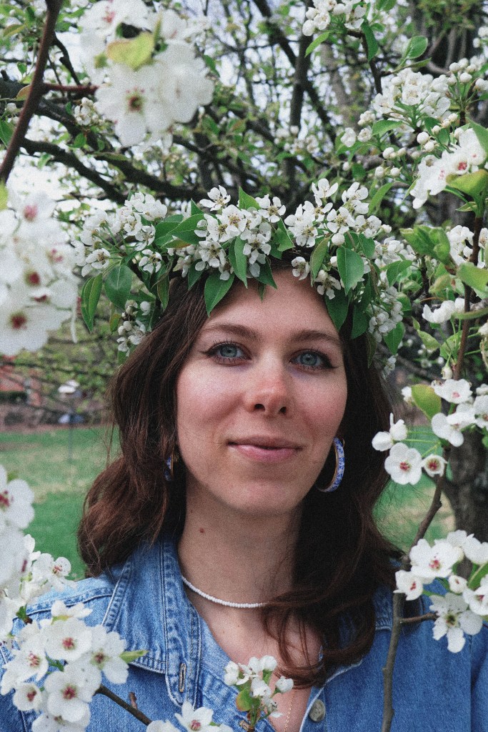 A girl standing surrounded by pear blossoms