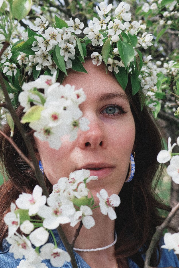 A girl standing surrounded by pear blossoms