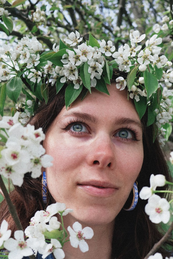 A girl standing surrounded by pear blossoms